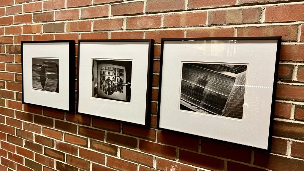 Black and white photos hung on a brick wall